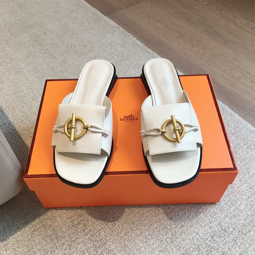 Close-up of Hermes signature hardware on white Isle Sandal