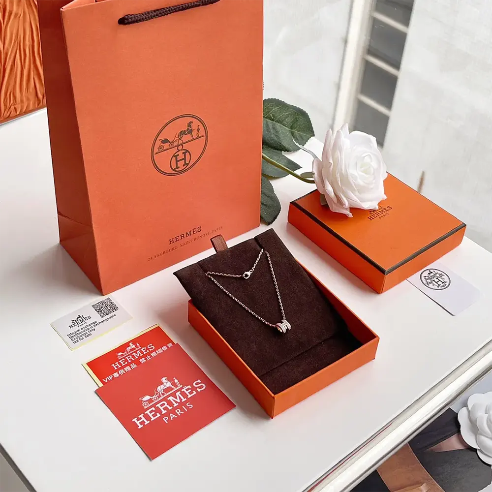 Close-up of gray leather texture and metal clasp on Hermes Mini Pop H Pendant