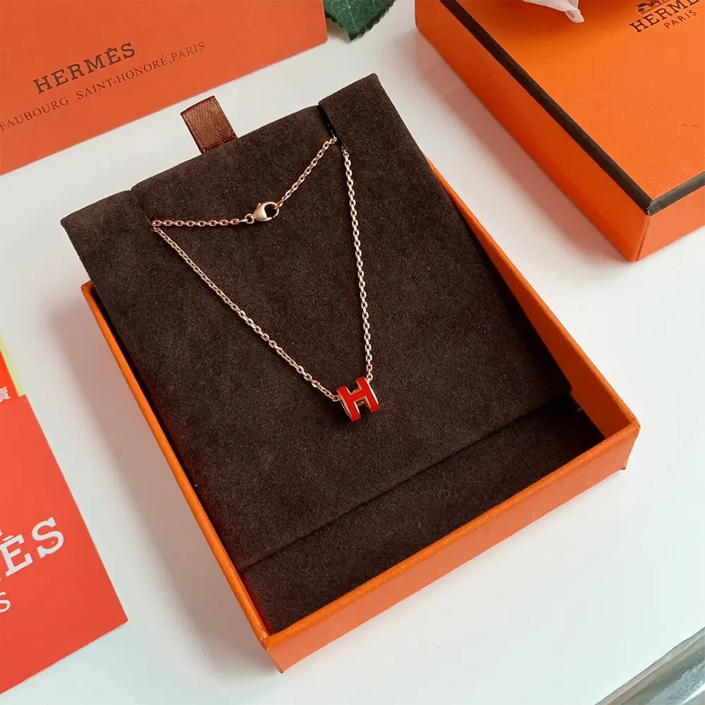 Styled flat lay of Hermes Women Mini Pop H Pendant-Red with accessories