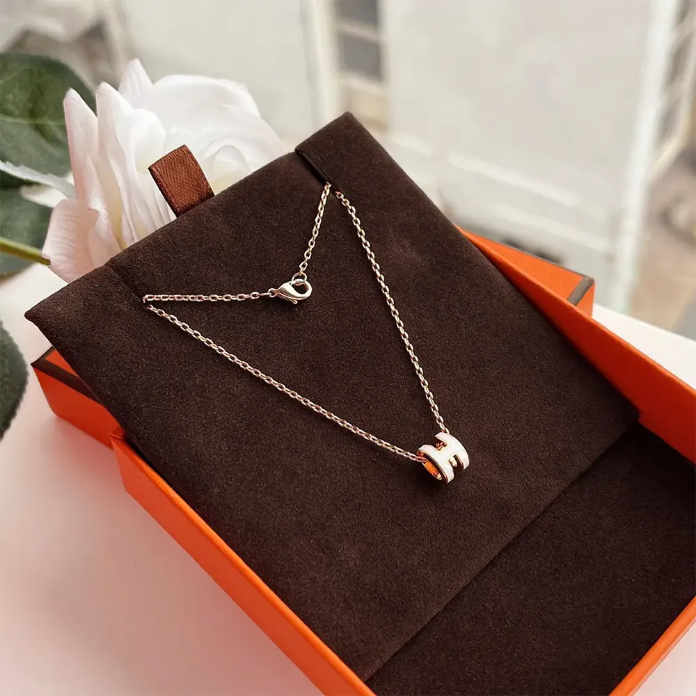 Side angle showcasing slim silhouette of Hermes Women Mini Pop H Pendant-White