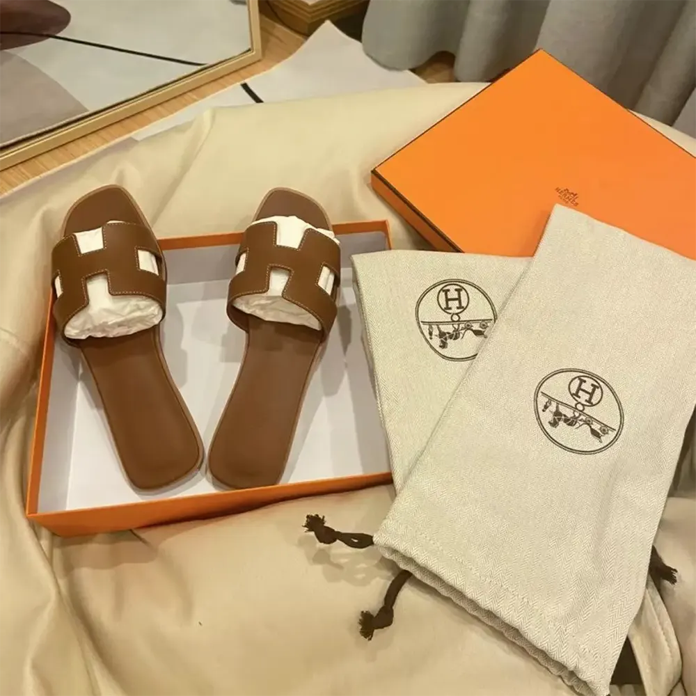 Close-up detail of brown leather and ‘H’ cutout on Hermes sandal