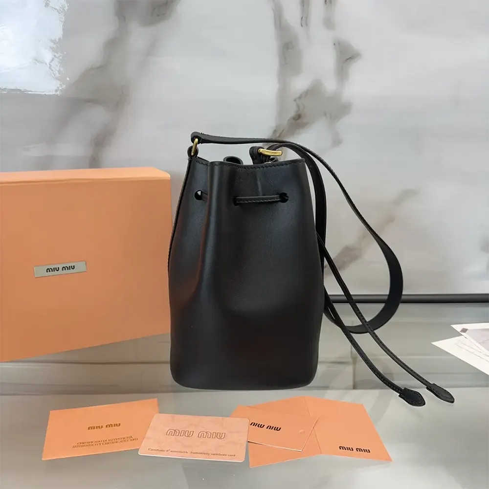 Side angle detail of magnetic closure on Miu Miu Women Leather Bucket Bag-Black