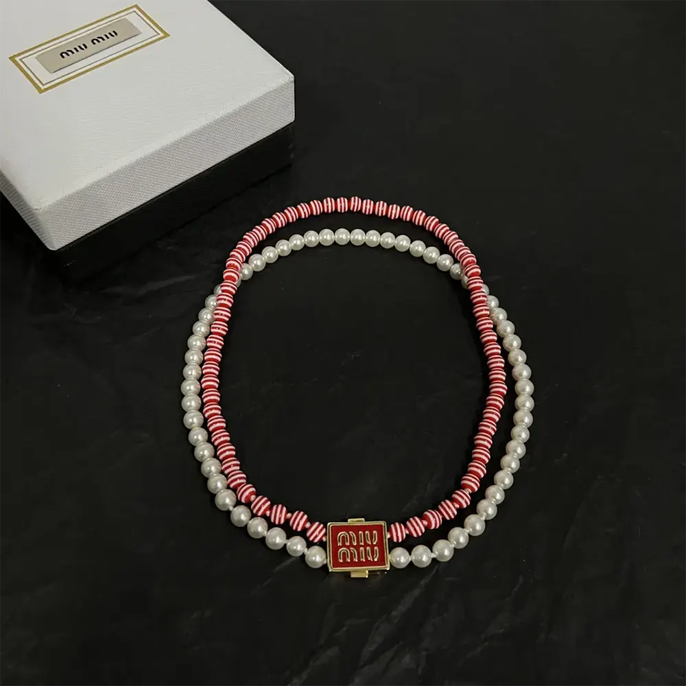 Close-up of shiny metal and synthetic pearl details on Miu Miu choker