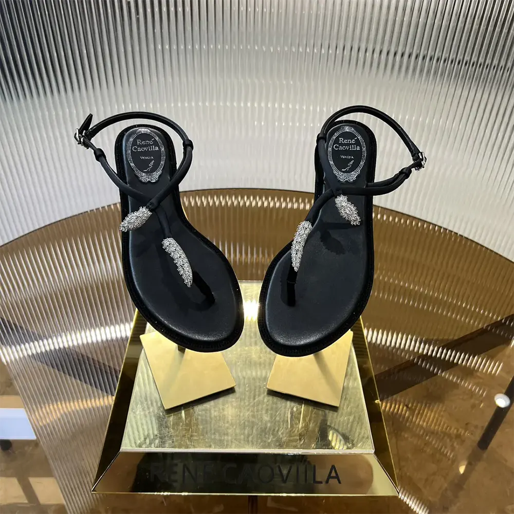 Close-up of black leather and crystal serpente detail on Rene Caovilla sandal