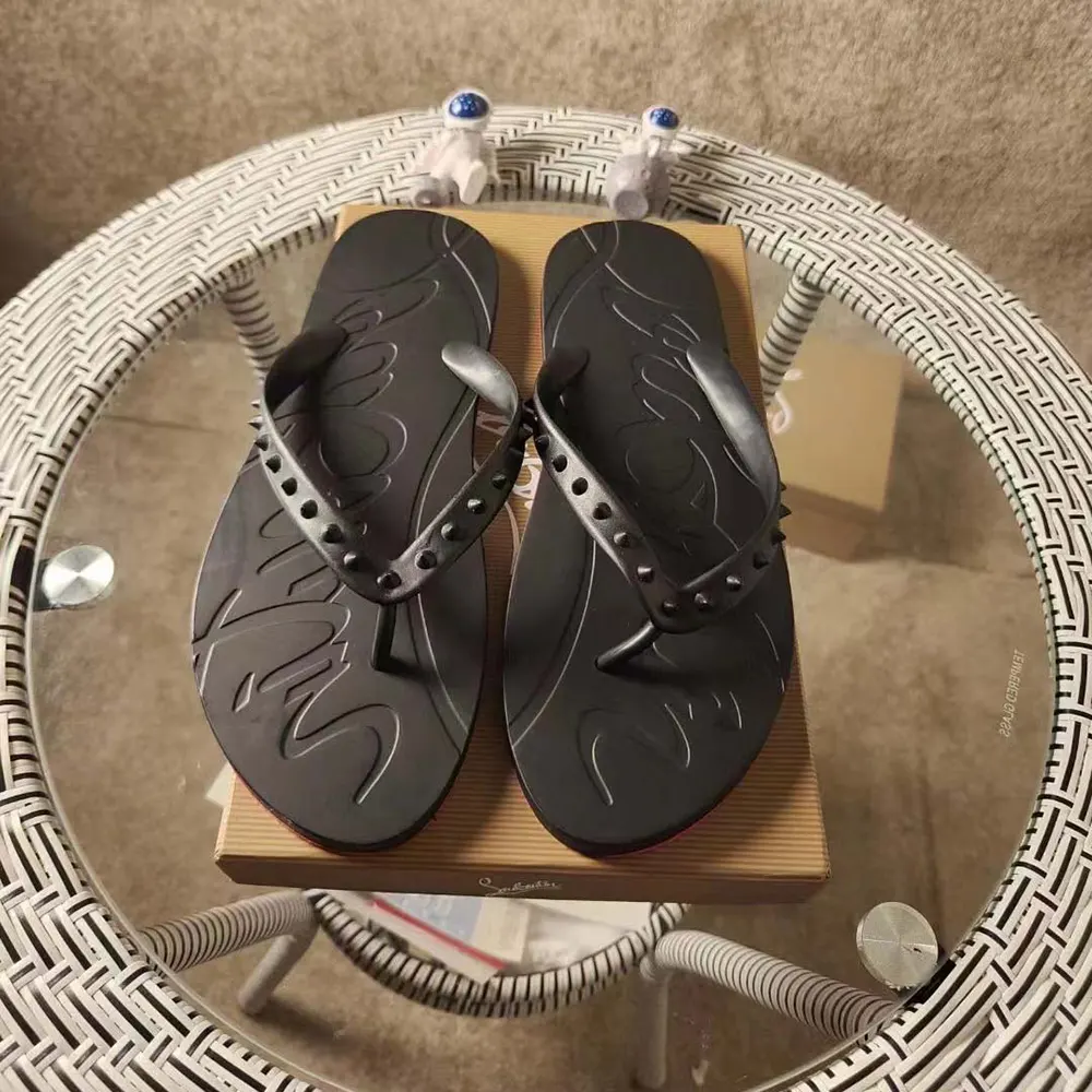 Close-up on silver spikes and red sole of Christian Louboutin Men Loubi Donna Flip Flops