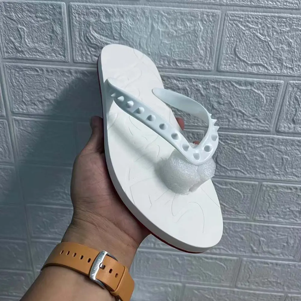 Close-up of white leather and spike detail on Christian Louboutin flip flops