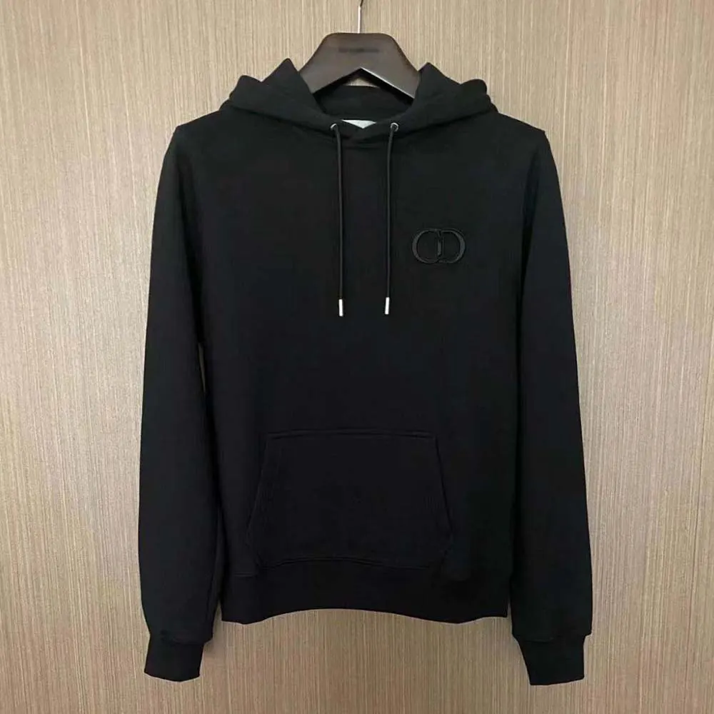 Close-up of Dior CD metal hardware on black cotton fleece hoodie