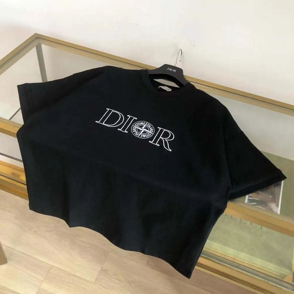 Close-up of Dior and Stone Island signature patch on black cotton jersey T-shirt
