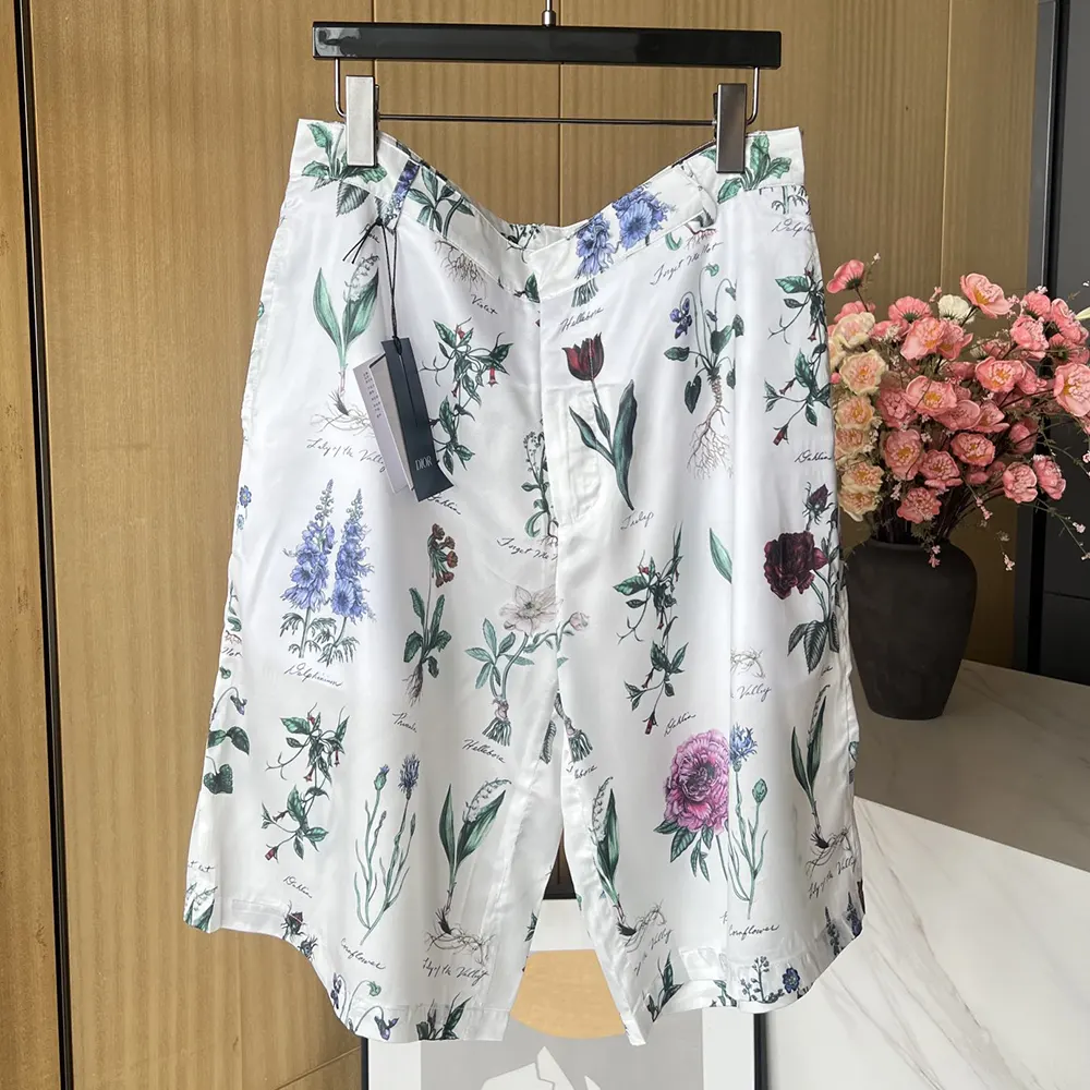 Close-up detail of herbarium print on white silk shorts by Dior Men