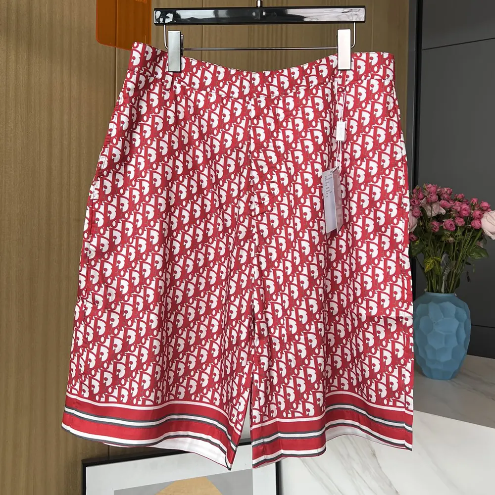 Close-up of Dior Oblique embossed hardware on the silk twill shorts