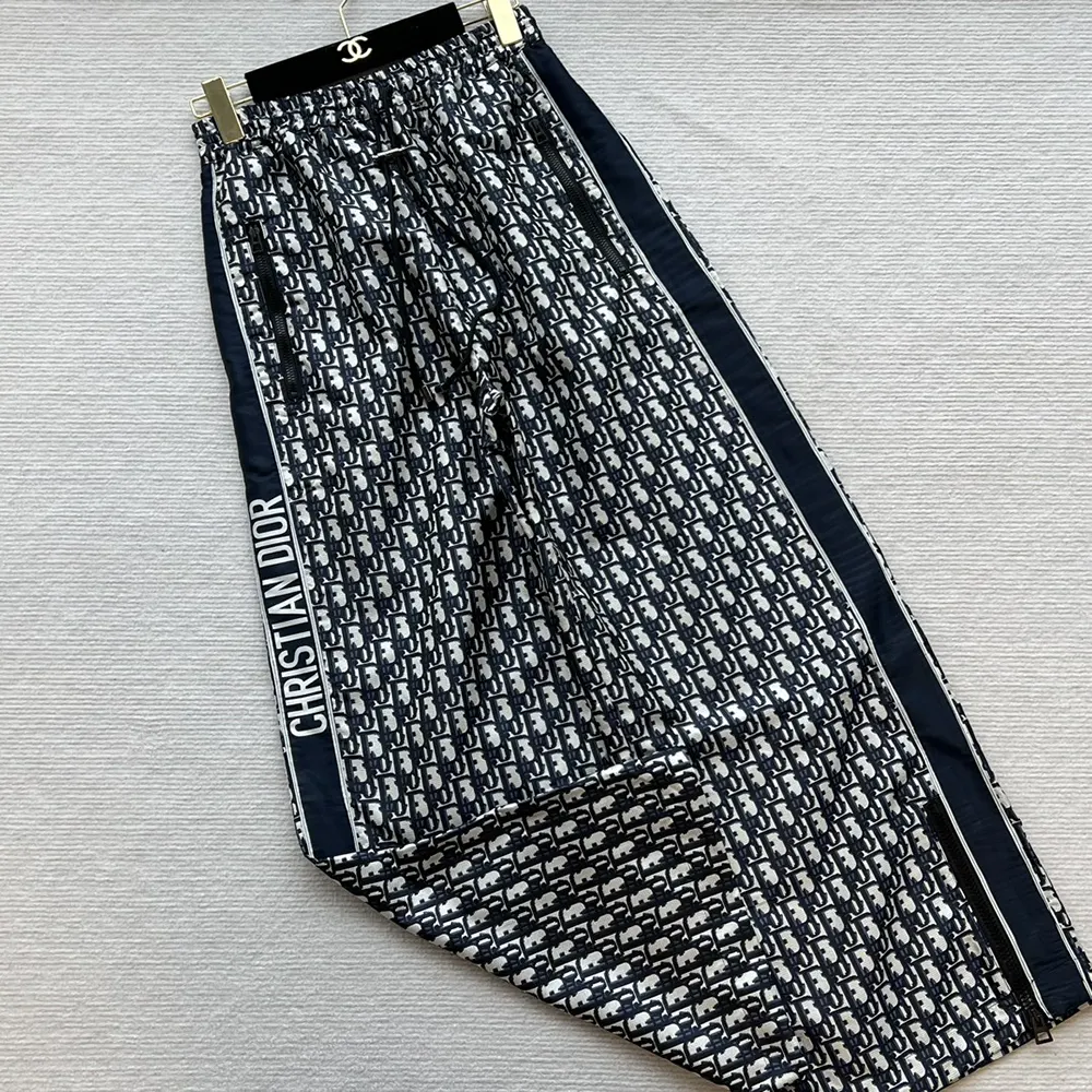 Close-up detail showing Dior Oblique motif on blue technical taffeta pants