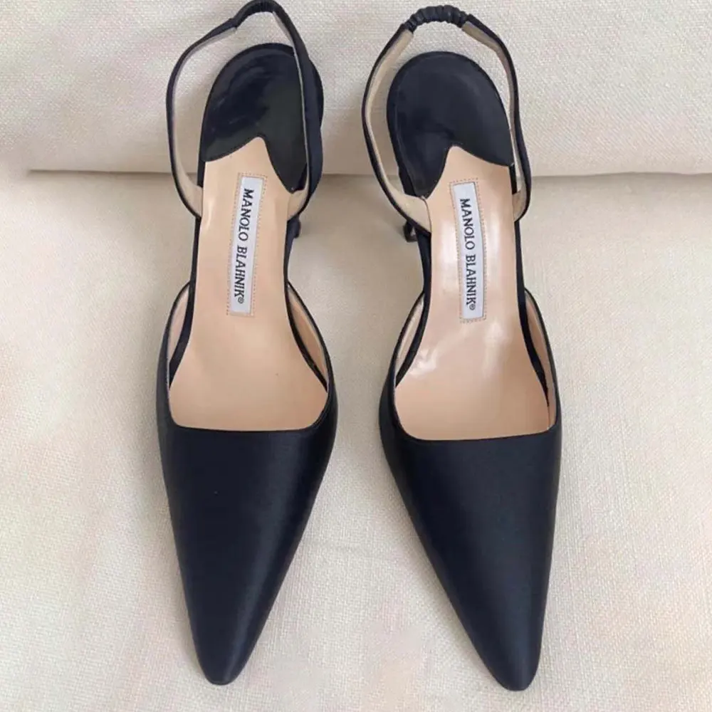Close-up detail of black suede and gold hardware on Carolyne 70 pumps