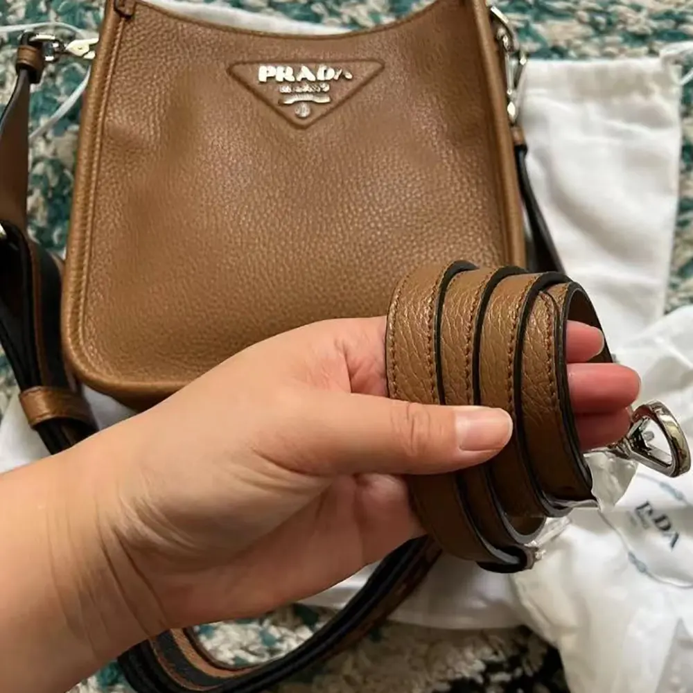 Side angle showing silhouette and strap of Prada Unisex Leather Mini Shoulder Bag