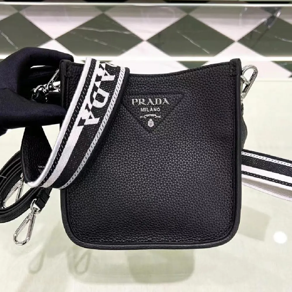 Close-up on Prada logo plaque and black leather texture