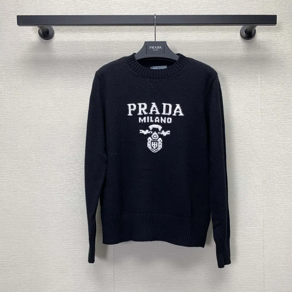 Close-up of embroidered Prada logo on black crew-neck sweater