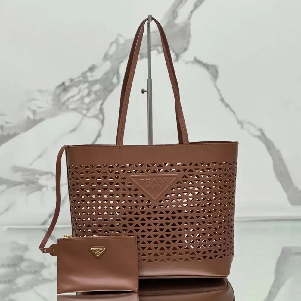 Close-up detail of perforated leather and gold-tone hardware on Prada tote