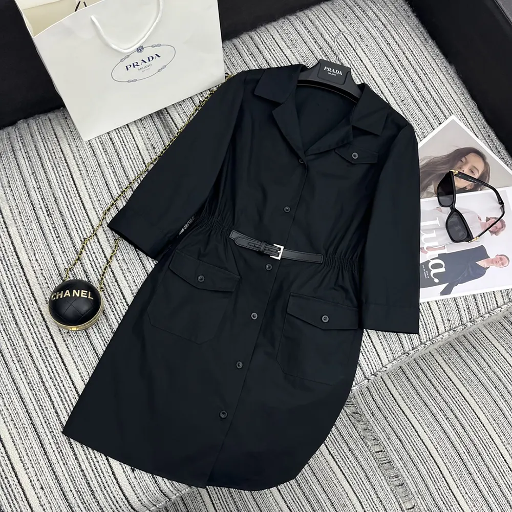 Close-up of Prada logo hardware on black poplin mini-dress