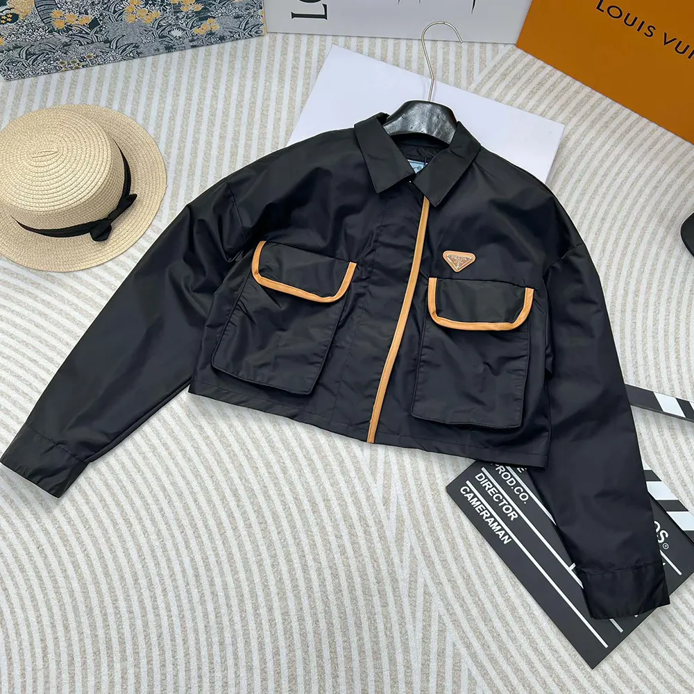 Close-up of Prada triangle logo plaque on black Re-Nylon Jacket