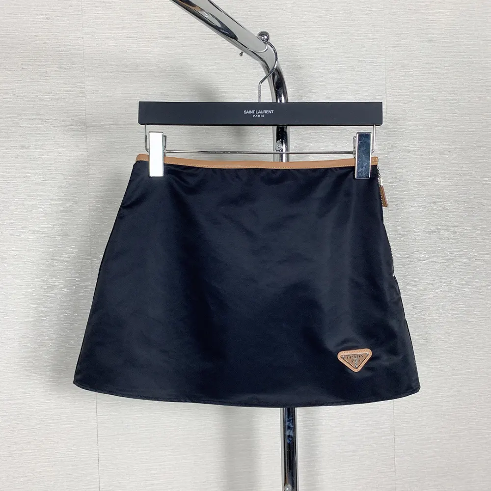 Close-up detail of Prada metal logo on Re-Nylon miniskirt