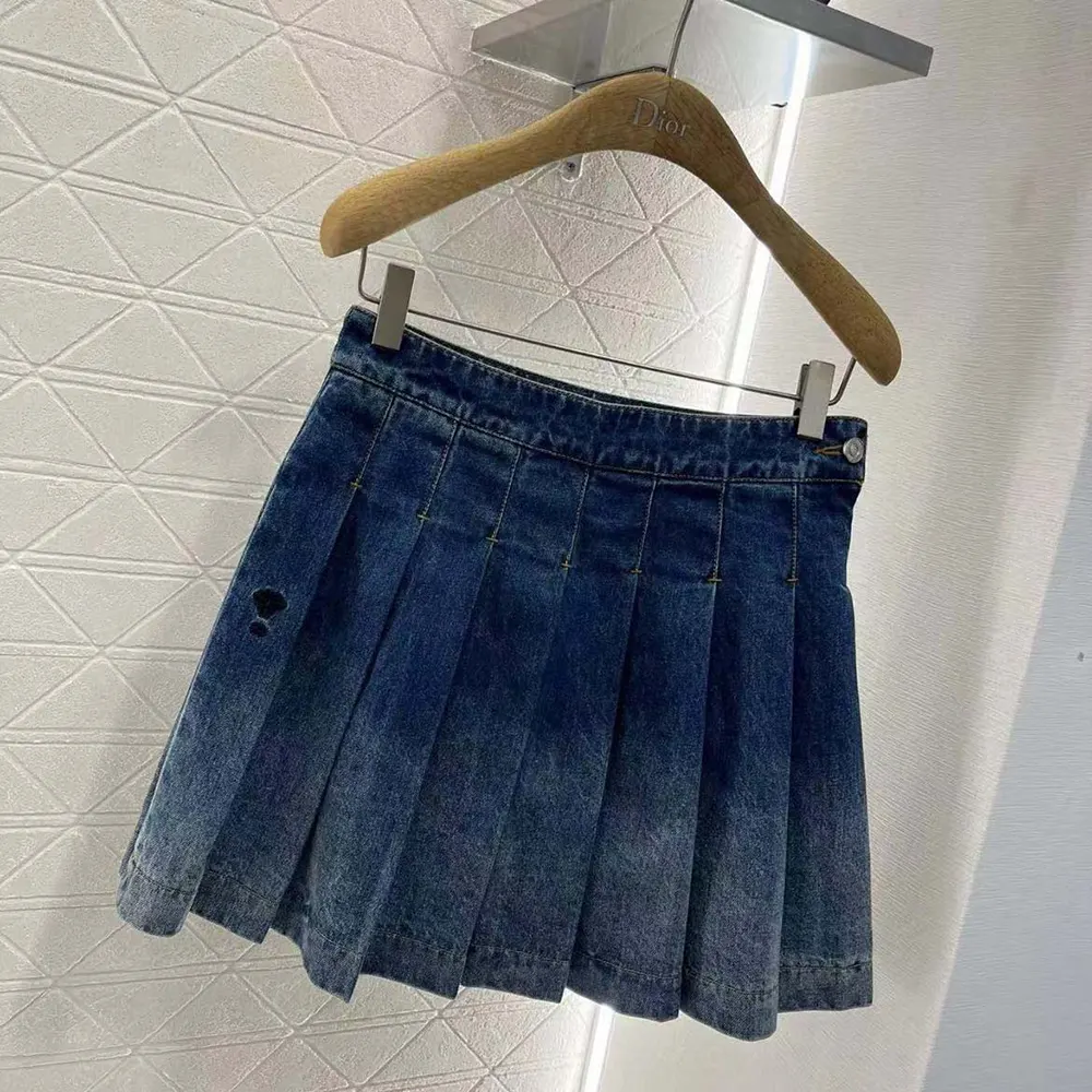 Close-up of signature Dior stitching on blue stonewashed denim miniskirt