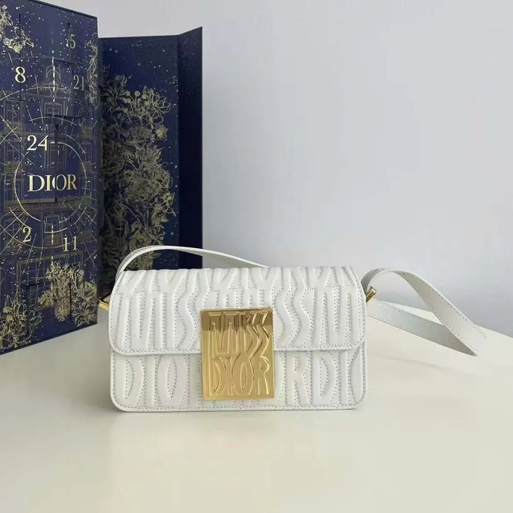 Close-up of quilted white calfskin and gold hardware on Dior Flap Bag