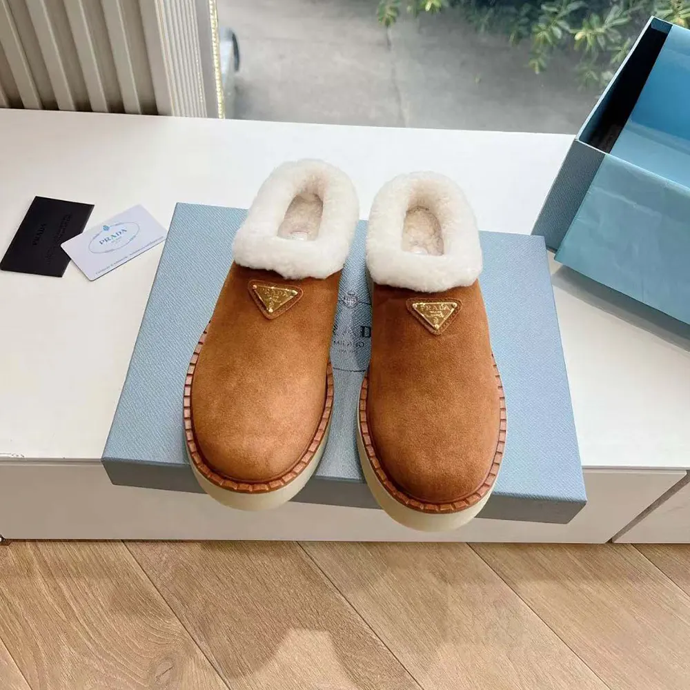 Close-up of Prada logo hardware on brown suede mule
