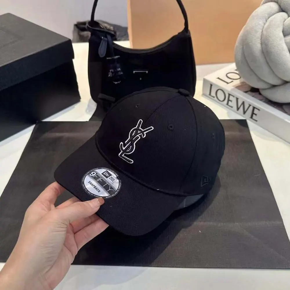 Close-up of YSL logo hardware on black gabardine cap