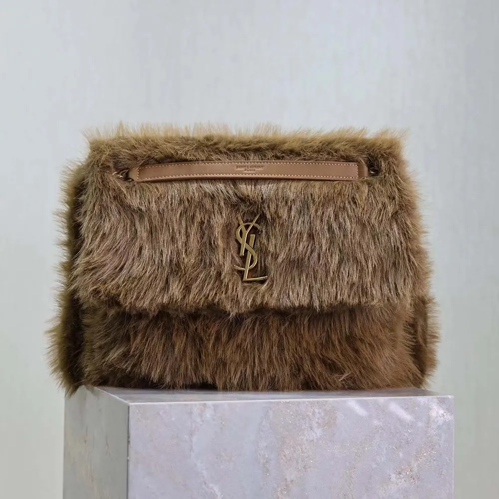 Close-up of gold YSL logo hardware on Niki Large Bag in shearling