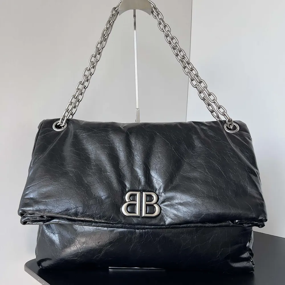 Close-up of smooth black leather and silver chain on Balenciaga bag