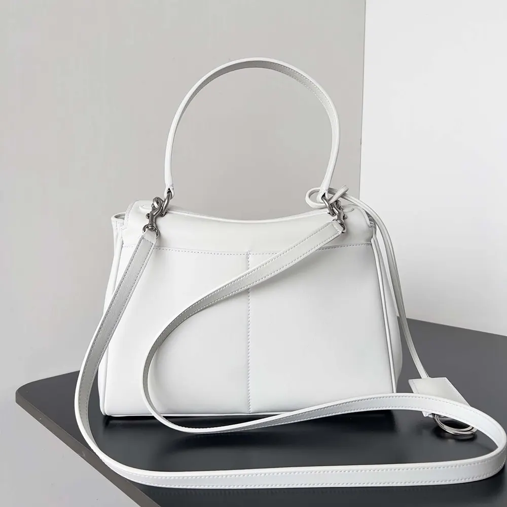 Side angle showing structured silhouette of white Balenciaga Rodeo handbag