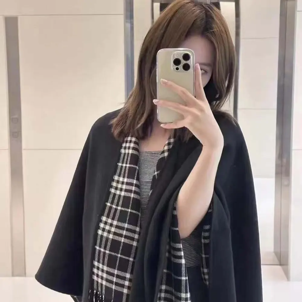 Close-up of Burberry check pattern detail on reversible wool cape black edition