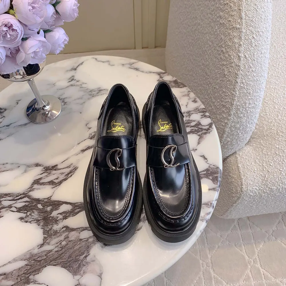 Close-up on abrasion detailing and red lug sole of Christian Louboutin loafers