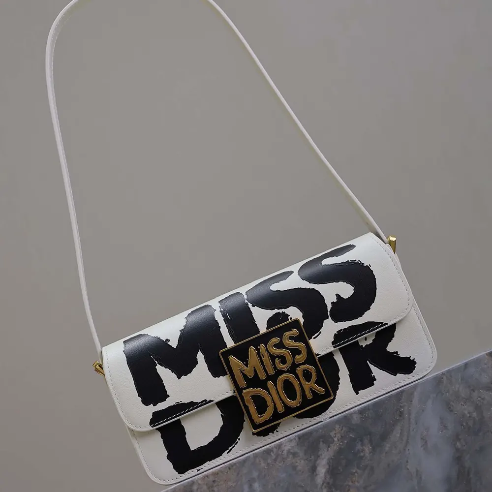 Side angle showing slim profile of Dior Women Miss Dior Flap Bag in white and black