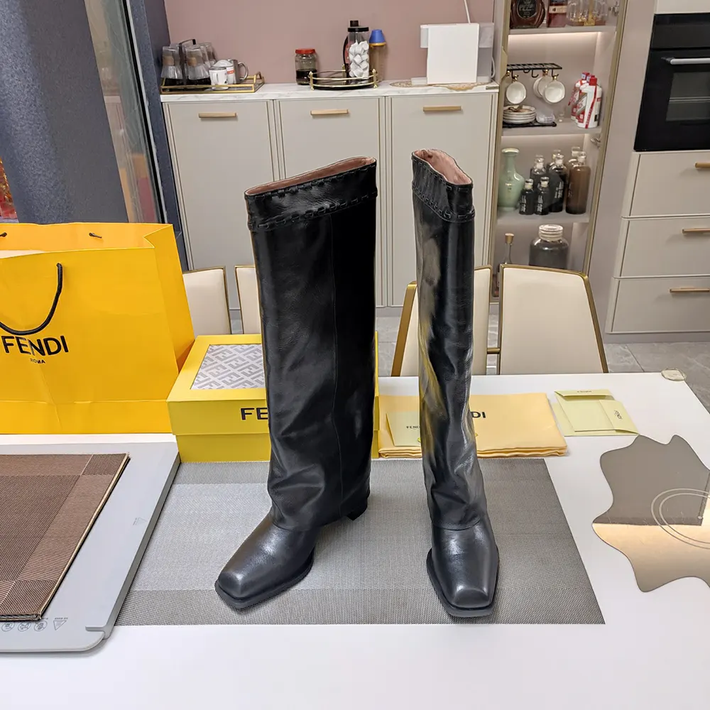 Close-up of Fendi logo hardware on black leather boots