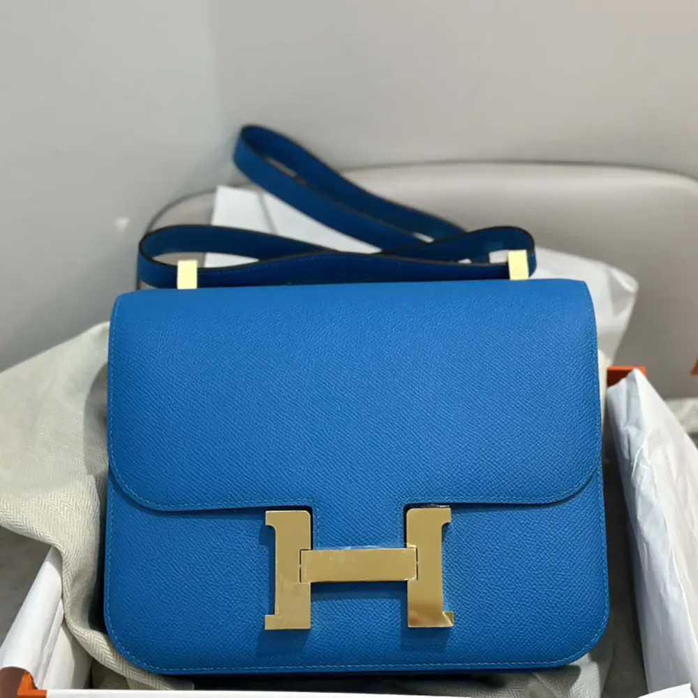 Close-up of gold H clasp and blue Epsom leather texture on Hermes bag