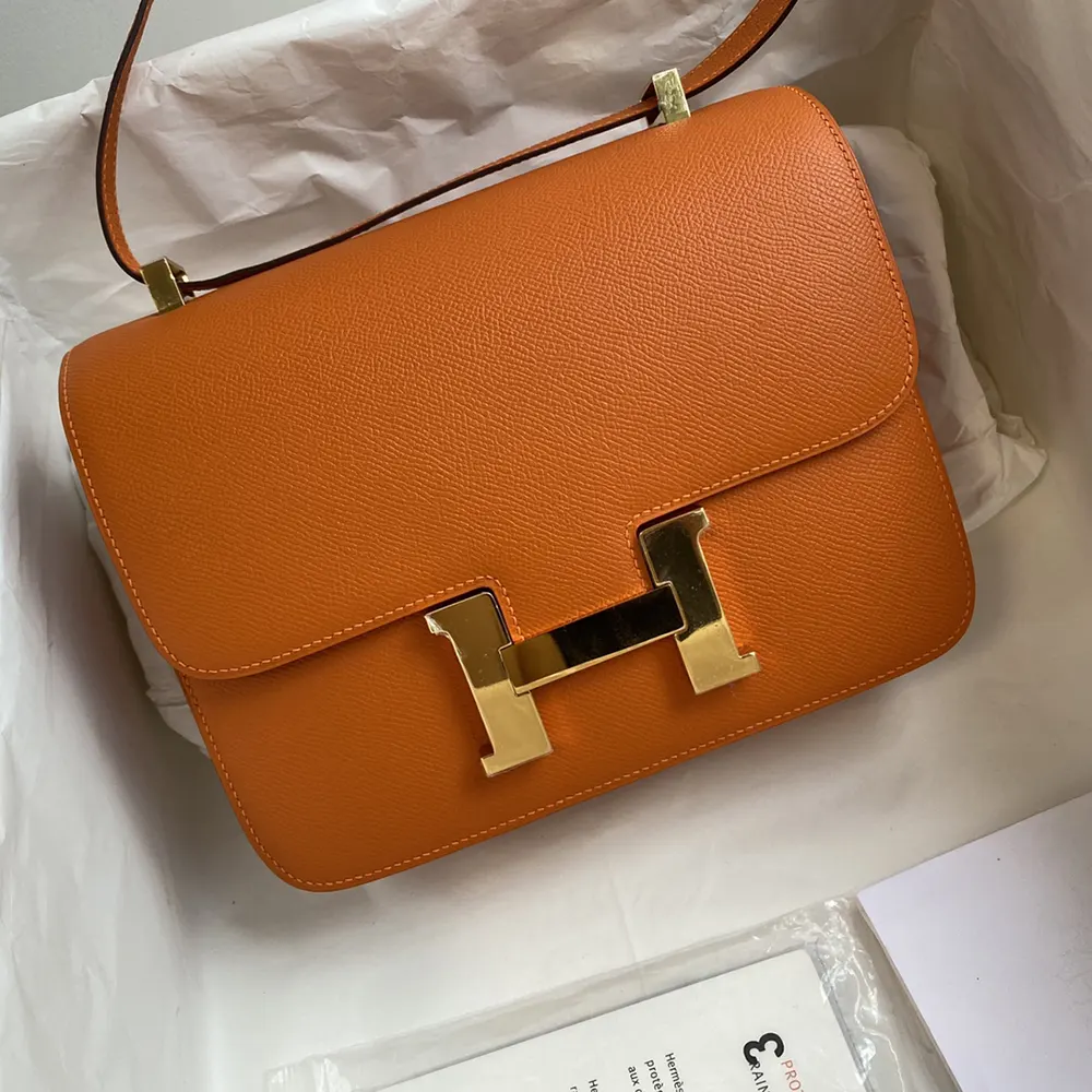 Close-up detail of Hermes orange leather and gold H clasp