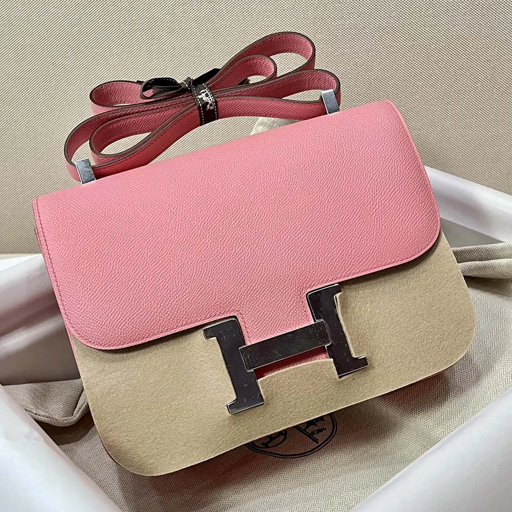 Side angle showcasing pink leather texture on Hermes Women Constance 24 Bag