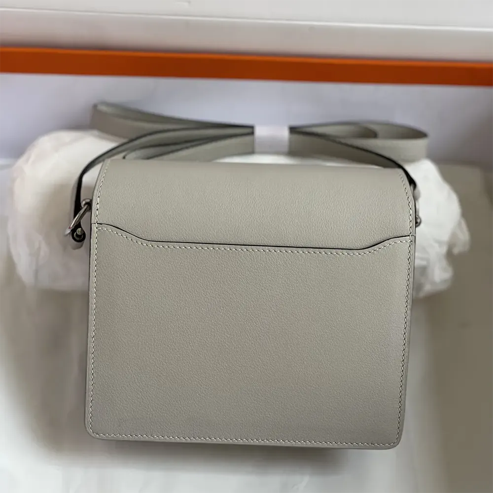 Side angle showing compact shape of Hermes Women Roulis Mini Bag
