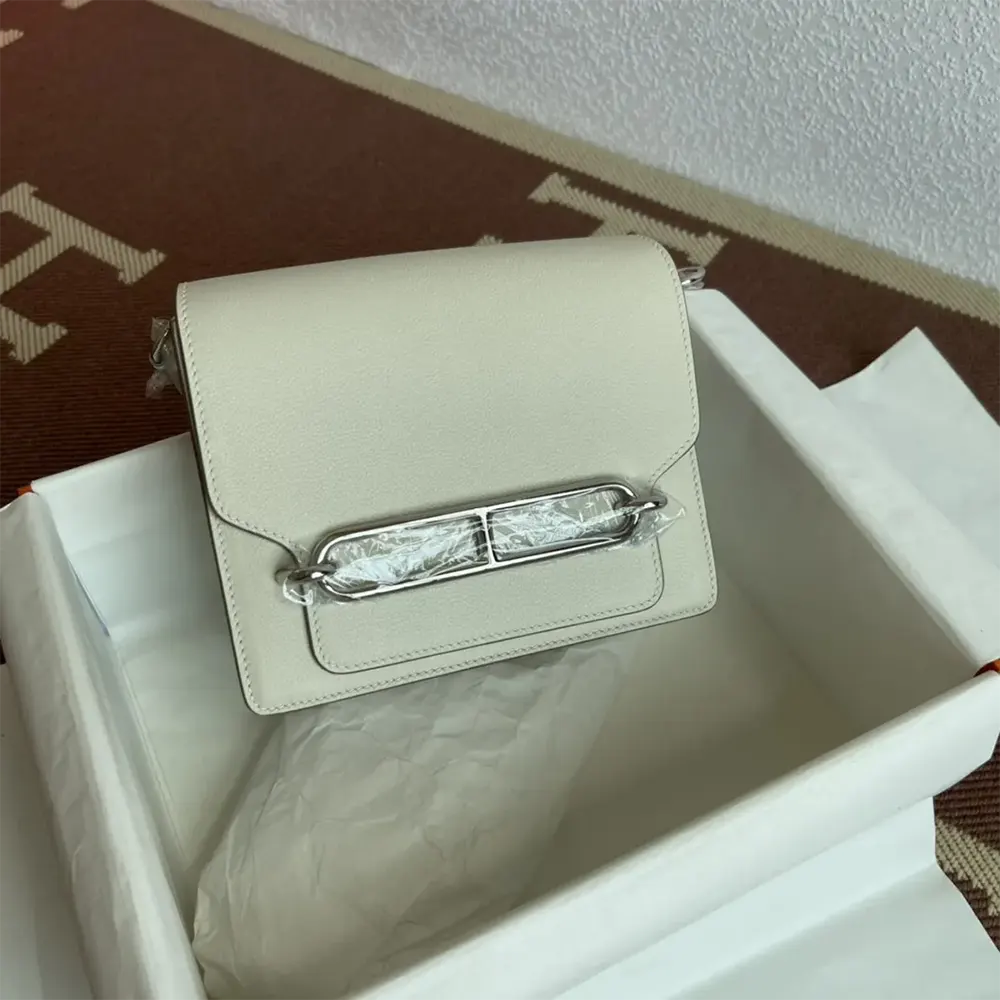 Close-up of silver 'H' clasp on Hermes Women Roulis Mini Bag white leather