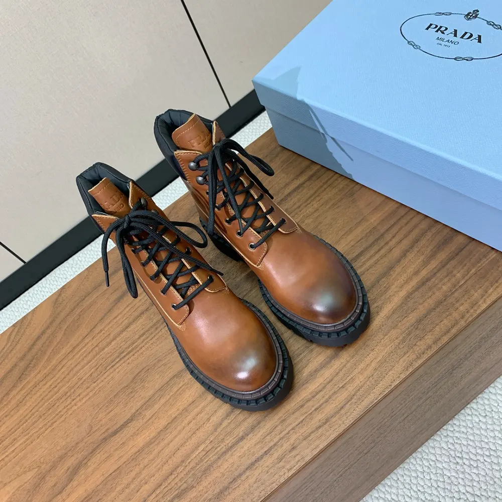 Close-up of Prada embossed hardware on brown leather booties