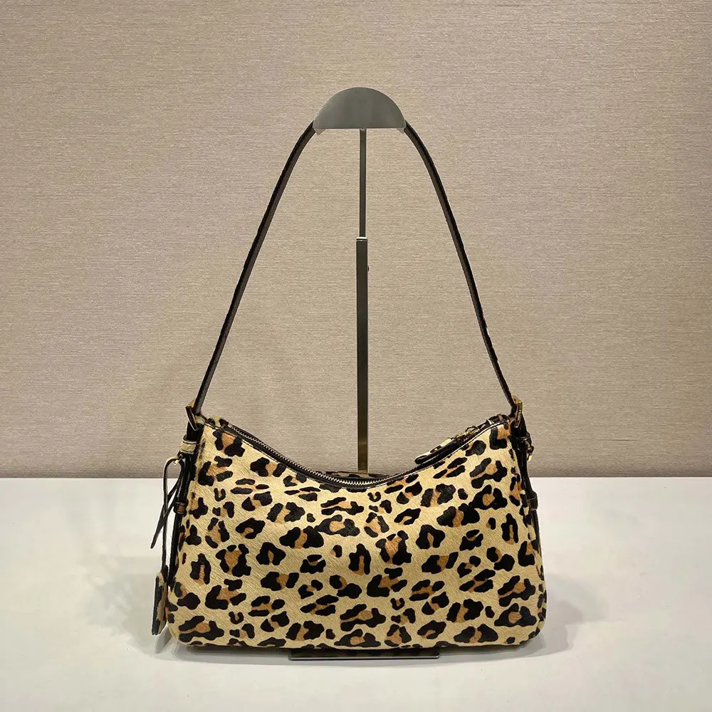 Close-up of gold-tone hardware on Prada Women Aimèe shoulder bag