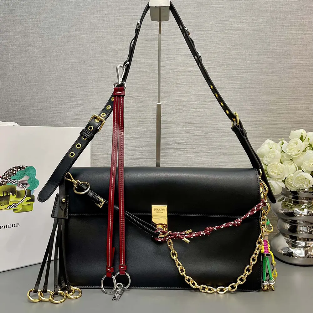 Close-up of silver-tone charms on Prada Women Soft Sound Large Leather Shoulder Bag