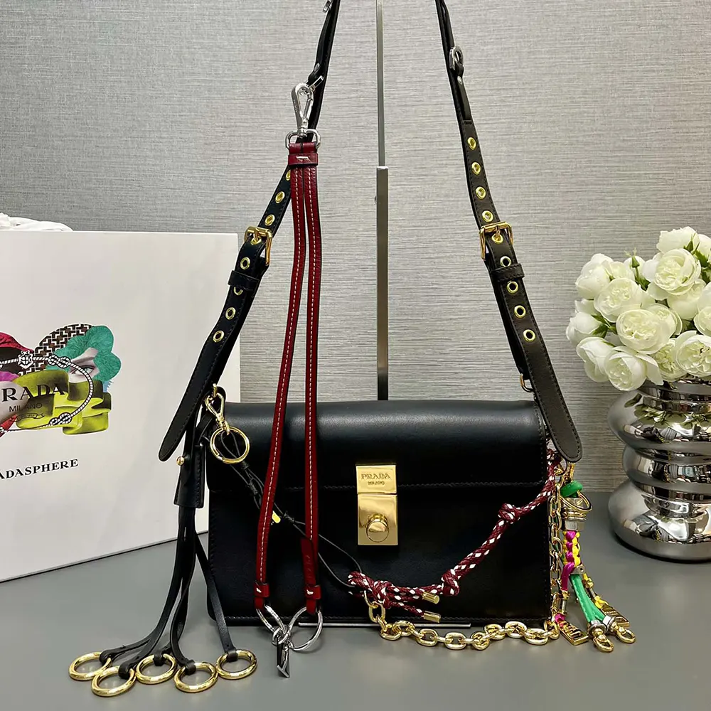 Close-up of polished charms on Prada Women Soft Sound Small Leather Shoulder Bag