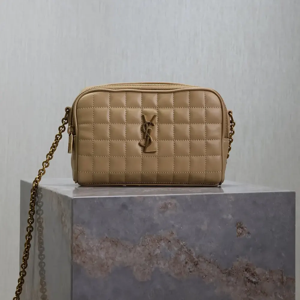 Close-up of gold YSL logo hardware on sandy Cassandre Matelassé Carré Camera Bag