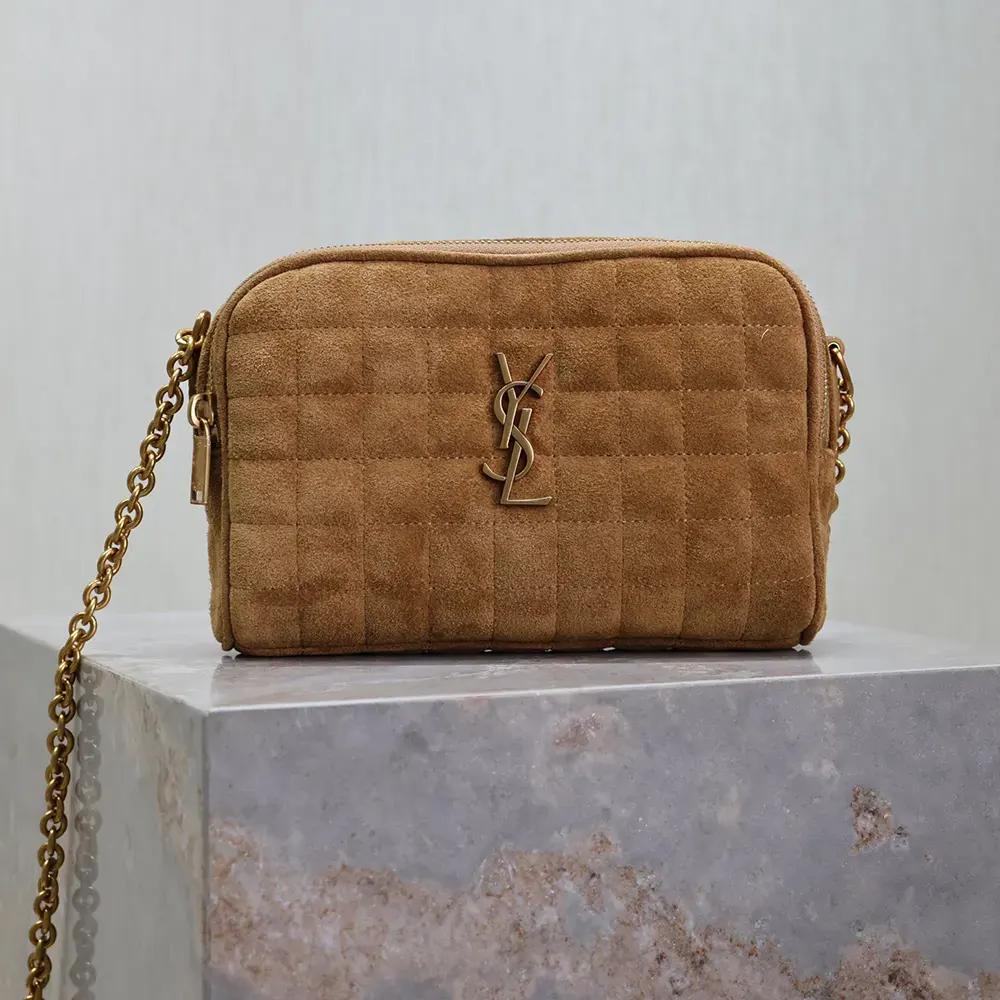 Close-up of gold YSL logo on brown suede Cassandre Matelassé Carré Camera Bag