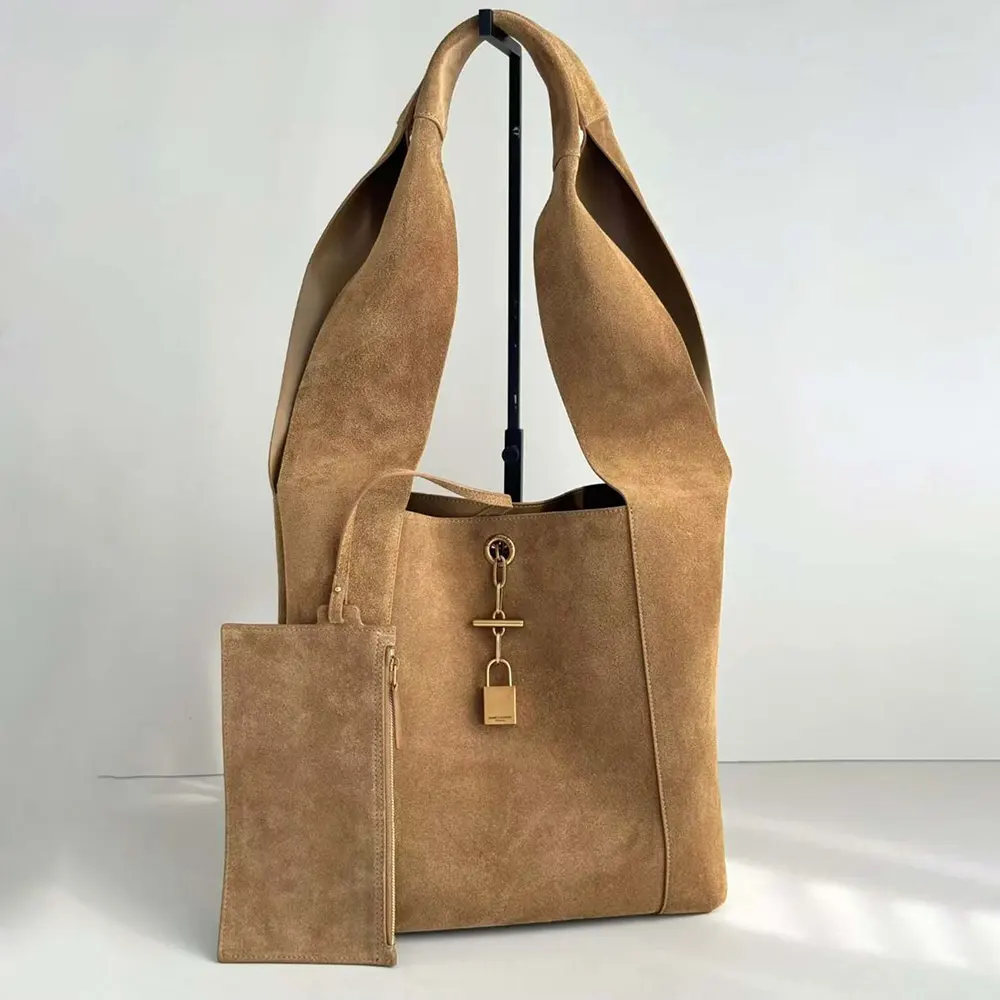 Close-up of YSL engraved logo and gold-tone hardware on shoulder bag