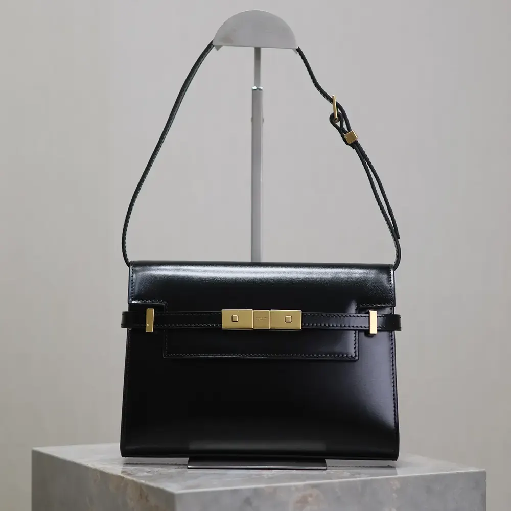 Close-up of gold-tone YSL logo and black box leather texture
