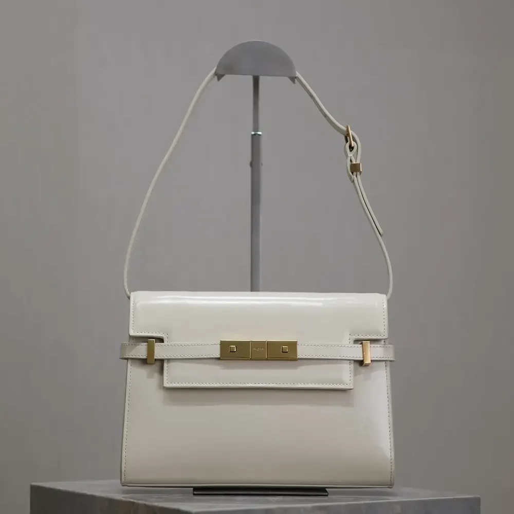 Close-up of silver YSL logo and clasp on white leather bag