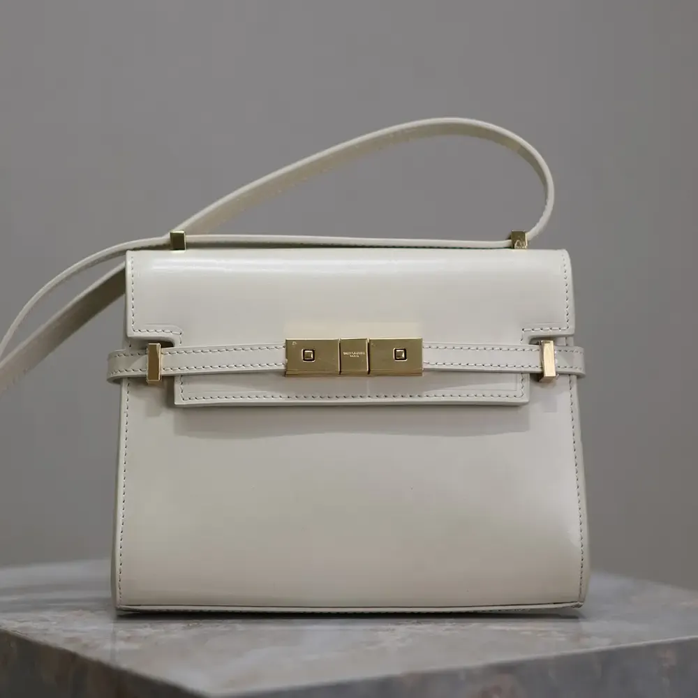 Close-up of gold YSL logo hardware on Saint Laurent Mini Manhattan white bag
