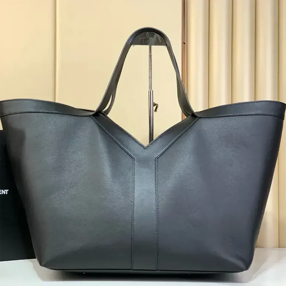 Close-up of gold YSL logo on black leather tote
